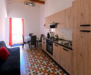 a kitchen with a sink and a table in it at Charming Townhouse - Steps from Waterfront in Marsaxlokk