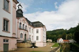 un gran edificio blanco con una torre de reloj en la parte superior en Charming 2 Bedroom House with Cozy Attic in Scenic Ferschweiler Perfect for Families!, en Ferschweiler
