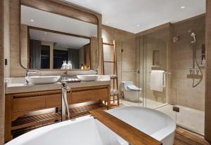 a bathroom with two sinks and a tub and a mirror at Holiday Inn Resort Bali Canggu by IHG in Canggu