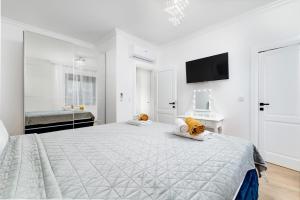 a white bedroom with a large bed and a flat screen tv at Villa Laura in Malinska +50 photos