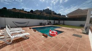 a swimming pool with two chairs and a red raft at Villa Espiga in Benalmádena