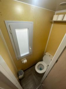 a small bathroom with a toilet and a window at Casă mobilă 3 in Constanţa +13 photos
