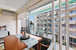 ein Raum mit einem Tisch und einem großen Fenster in der Unterkunft Precioso Piso Frente Al Mar in Vilanova i la Geltrú