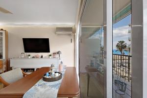 ein Wohnzimmer mit einem Esstisch und einem TV in der Unterkunft Precioso Piso Frente Al Mar in Vilanova i la Geltrú