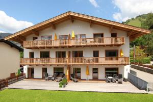 duży budynek z balkonem, stołami i krzesłami w obiekcie Appartement Haus Sonne w mieście Zell am See