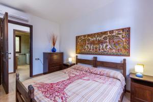 a bedroom with a bed and a painting on the wall at Holiday Home Le Sirene in Fort Village