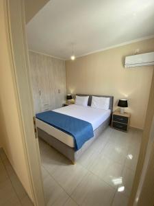 a bedroom with a large bed with a blue blanket at Sappir House in Pigadhákia