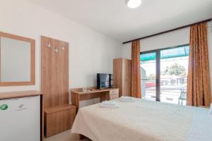 a bedroom with a bed and a tv and a window at Villa Ljupce in Ohrid
