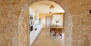 Un arco en una cocina con mesa y comedor en helidoni luxury villa, en Kokkíni Khánion