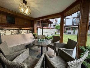 a patio with wicker chairs and a table and a stone wall at Guest House Ivan in Bansko +20 photos