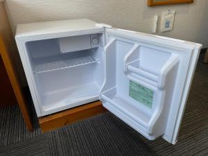 an empty refrigerator with its door open in a room at Terminal Hotel Matsuyama in Matsuyama