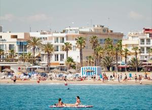 two people on a surfboard in the water near a beach at TARONGERS MIRAMAR PLAYA - Alquiler solo a Familias in Miramar