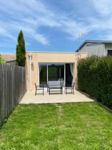 a patio with two benches in a yard at Maison moderne avec jardin in Saint-Xandre