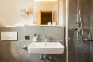 a bathroom with a sink and a shower at Hotel Restaurant Ancho in Cölbe