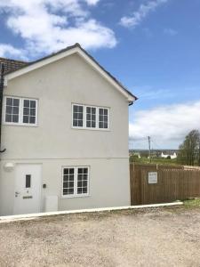 a white house with a fence in front of it at Idyllic location, Amazing view, Spacious in Marazion