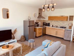 a living room with a couch and a kitchen at Maison moderne avec jardin in Saint-Xandre +8 photos