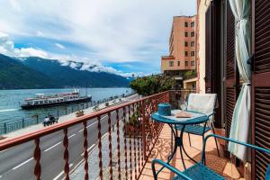 a balcony with a table and a view of the water at Portici Brentano - by MyHomeInComo in Tremezzo