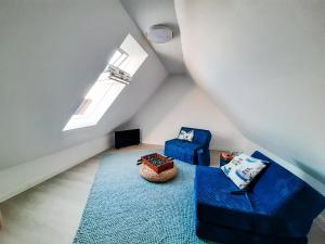 Una habitación en el ático con dos sillas azules y una alfombra azul. en Ferienhaus Auen, en Maasholm