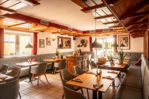 a restaurant with wooden tables and chairs and windows at Hotel Restaurant Ancho in Cölbe