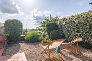 コルトーナにあるBorgo La Fonte - Together in Tuscanyの椅子2脚と花と生け垣のある庭