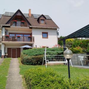 dom z werandą i huśtawką w ogrodzie w obiekcie Balázs Apartman w Tihany