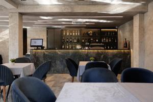 a restaurant with tables and chairs and a bar at Vetus Hotel in Prishtinë