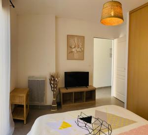 a living room with a bed and a television at Maison moderne avec jardin in Saint-Xandre