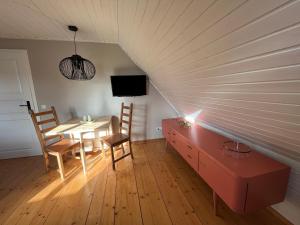 a room with a table and chairs and a tv at Fischerhus37 FeW Jasmund in Polchow +11 photos