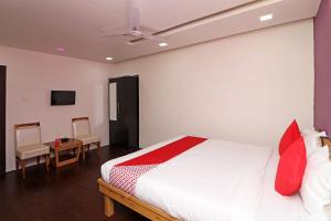 a bedroom with a bed and two chairs and a tv at Hotel O Krishna Hotel and Restaurant in Raipur +16 photos