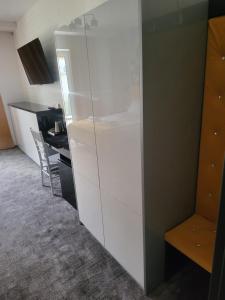 a white cabinet in a room with a desk at Avangarda in Wisznice