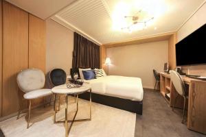 a hotel room with a bed and a desk at Bay 202 Hotel in Busan