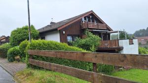 a house with a fence in front of it at Odenwald Ferienwohnung - Infrarot-Sauna-Parkplatz-Waschmaschine-WLAN in Schwanheim