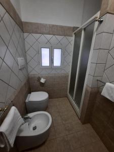 a bathroom with a toilet and a sink and a shower at Viccinella House in Capranica