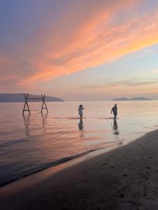 two people walking in the water on the beach at Linda’s apartment in Vlorë