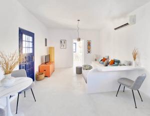 Sala de estar blanca con 2 camas y sofá en Karpimo North - Sunset view - Private Jacuzzi - up to 4pp, en Fira