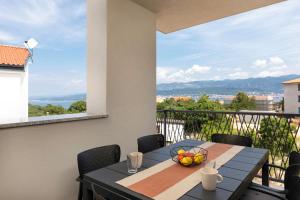 a table with a bowl of fruit on a balcony at Apartman sa pogledom na more- Petra in Šilo