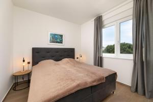 a bedroom with a large bed and a window at Apartman sa pogledom na more- Petra in Šilo +20 photos