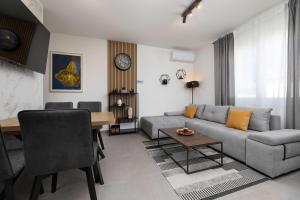 a living room with a couch and a table at Apartman sa pogledom na more- Petra in Šilo