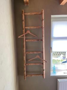 a wooden shelf hanging on a wall next to a window at Fischerhus37 FeWo Kranichwiese in Polchow +18 photos