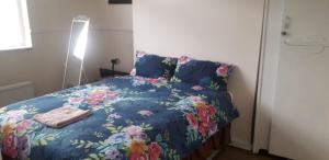 a bedroom with a bed with a blue comforter at Sports City Guest House in Manchester