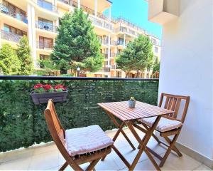a wooden table and two chairs on a balcony at MATEO Golden Sands 2 in Golden Sands