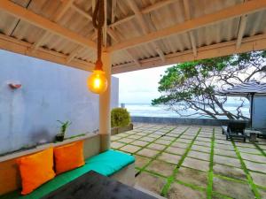 a patio with orange and green pillows and an umbrella at Villa Thalpe Breeze in Unawatuna