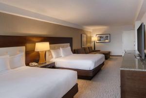 a hotel room with two beds and a couch at DoubleTree by Hilton Washington DC – Crystal City in Arlington