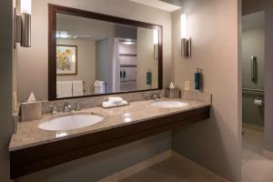 a bathroom with two sinks and a large mirror at DoubleTree by Hilton Washington DC – Crystal City in Arlington