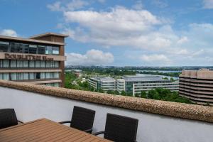 a balcony with a table and chairs and a building at DoubleTree by Hilton Washington DC – Crystal City in Arlington