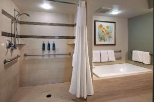 a bathroom with a tub and a shower with towels at DoubleTree by Hilton Washington DC – Crystal City in Arlington