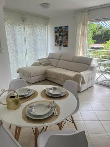 a living room with a couch and a table and chairs at Apartment Tihana in Cres