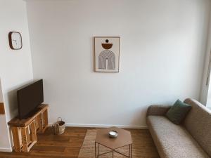 a living room with a couch and a tv at Ferienwohnung Röttgen in Winningen