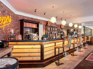 a bar with chairs and a brick wall at Mercure Bristol Grand Hotel in Bristol
