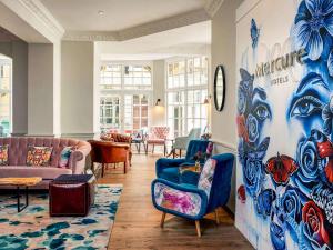 a living room with blue chairs and a large mural at Mercure Bristol Grand Hotel in Bristol